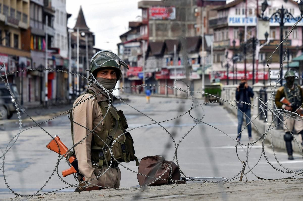 Srinagar: A security person stands guard during restrictions and strike called by separatists against Prime Minister Narendra Modi's visit to the state, at Lal Chowk, in Srinagar, on Saturday. (PTI Photo/S Irfan) (PTI5_19_2018_000048A)