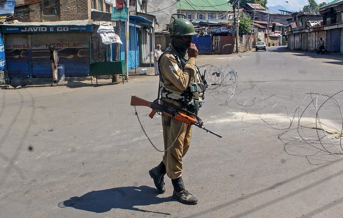A CRPF personnel stands guard on a road during a strike, in Srinagar. (PTI file photo)