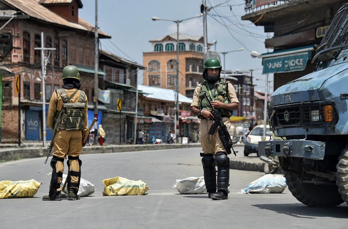 CRPF personnel stand guard during restrictions at Downtown Nowhatta, in Srinagar on Friday. (PTI Photo)