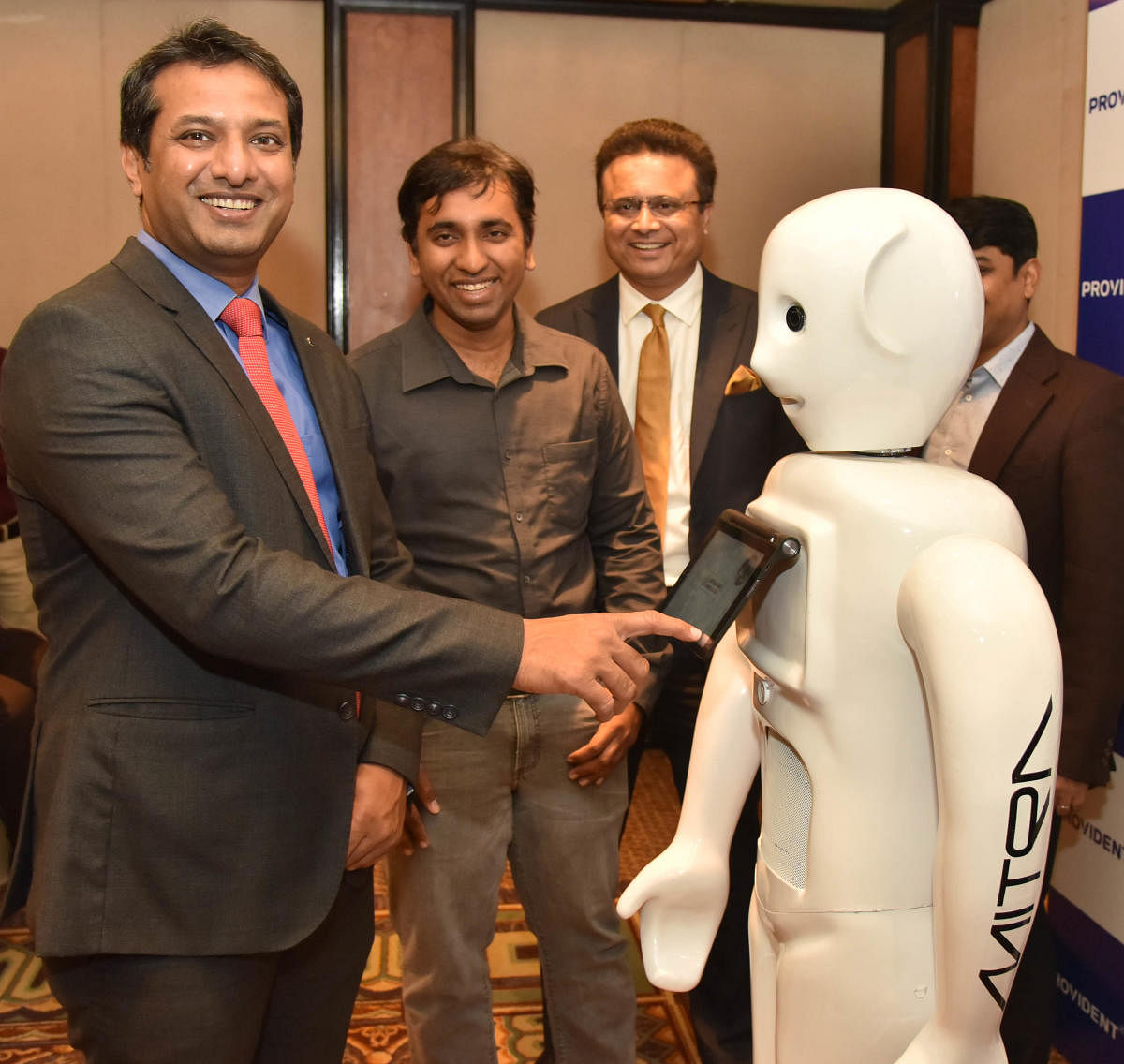 Puravankara Limited COO Anand Narayanan interacts with the robot. DH Photo