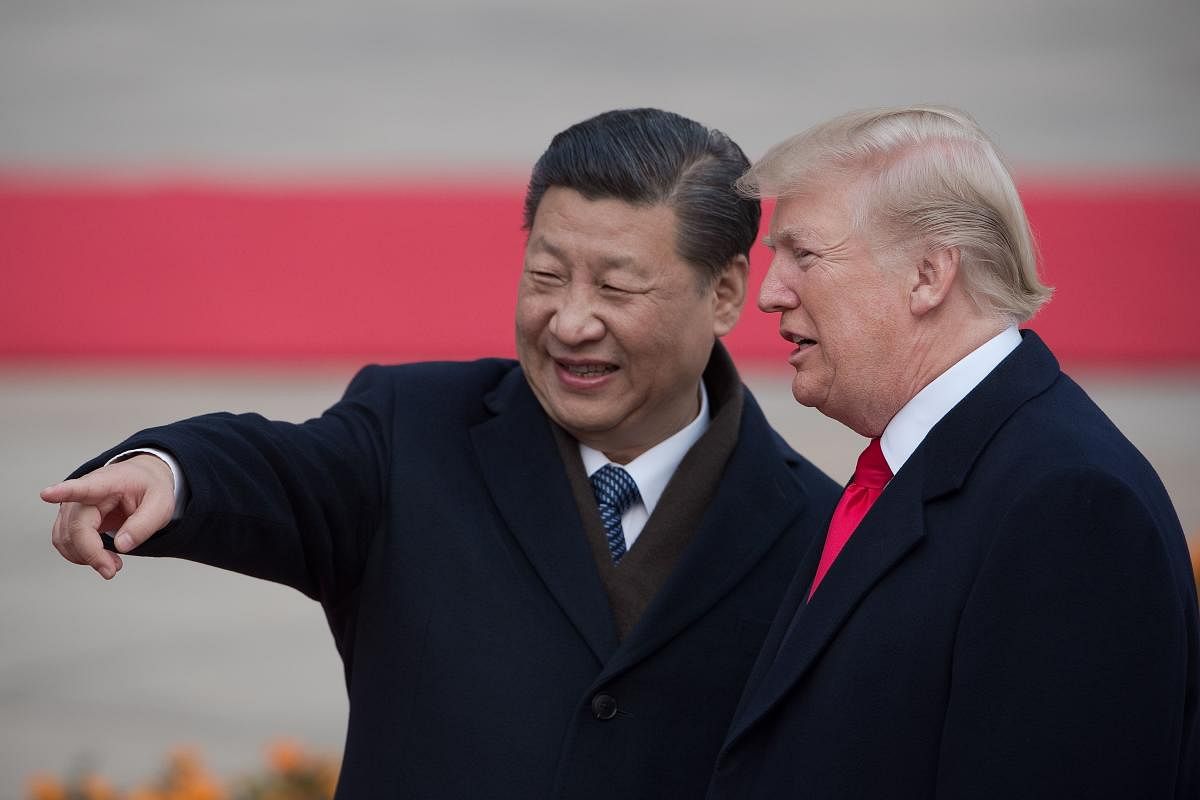 Chinese President Xi Jinping and US President Donald Trump attend a welcome ceremony at the Great Hall of the People in Beijing on November 9, 2017. Trump on September 18, 2018 accused China of seeking to influence upcoming US elections by taking aim at h