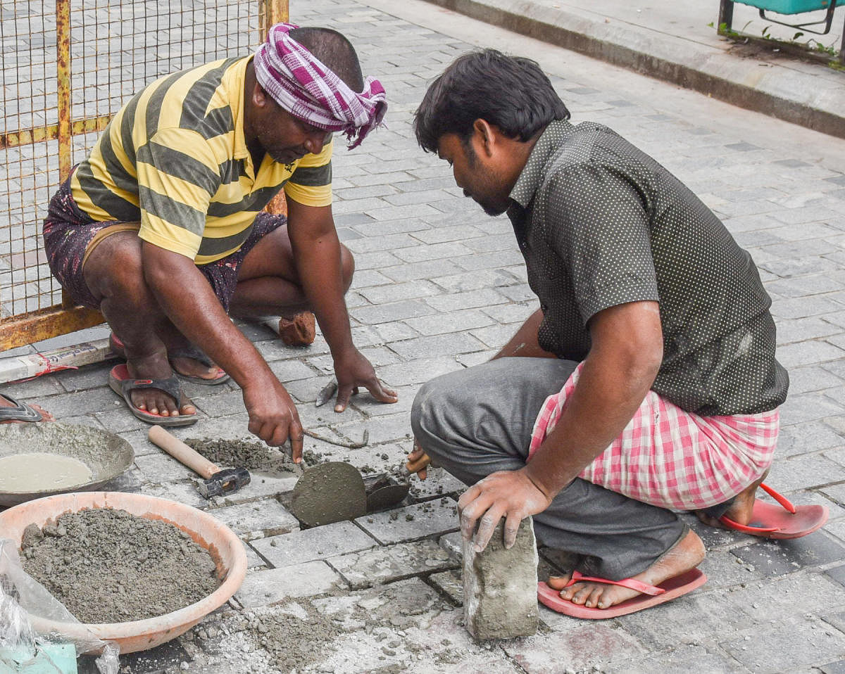 Workers repair a loosened cobblestone on Church Street, Bengaluru, on Friday. DH PHOTO/S K Dinesh