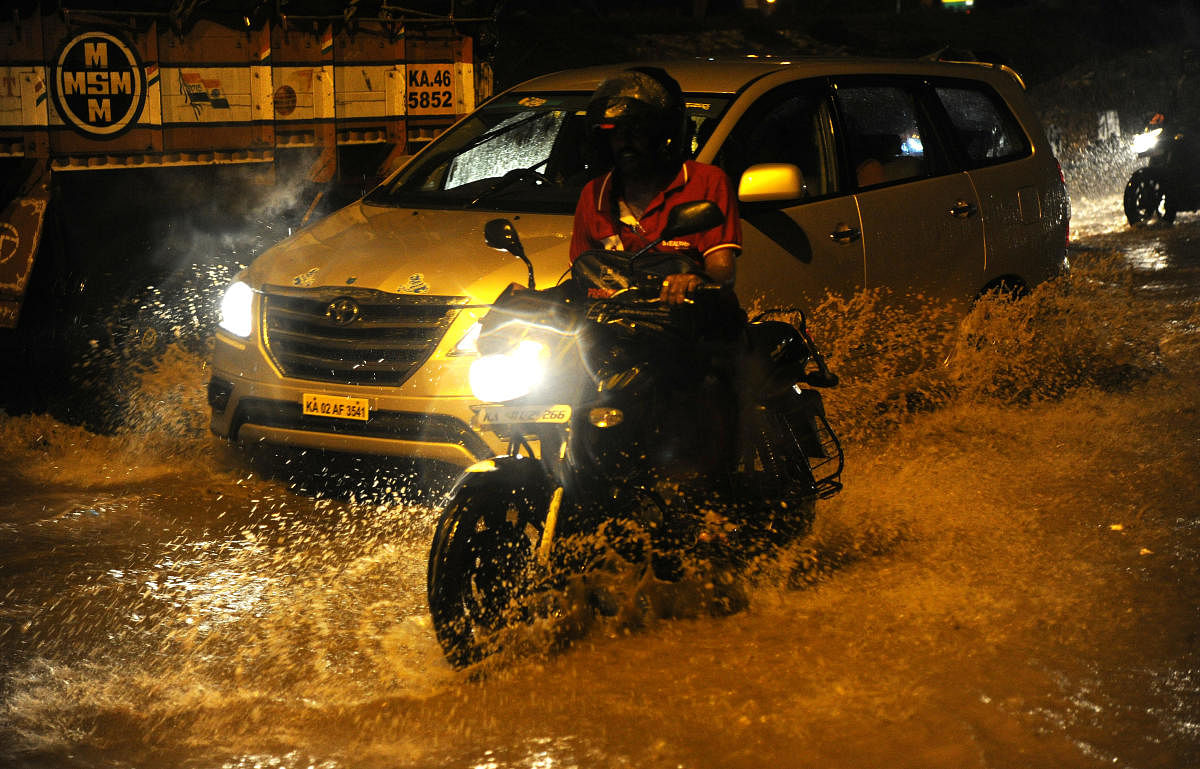 Motorists struggle to navigate the waterlogged Mysuru Road at Nayandanahalli junction on Wednesday night. DH PHOTO/Srikanta Sharma R