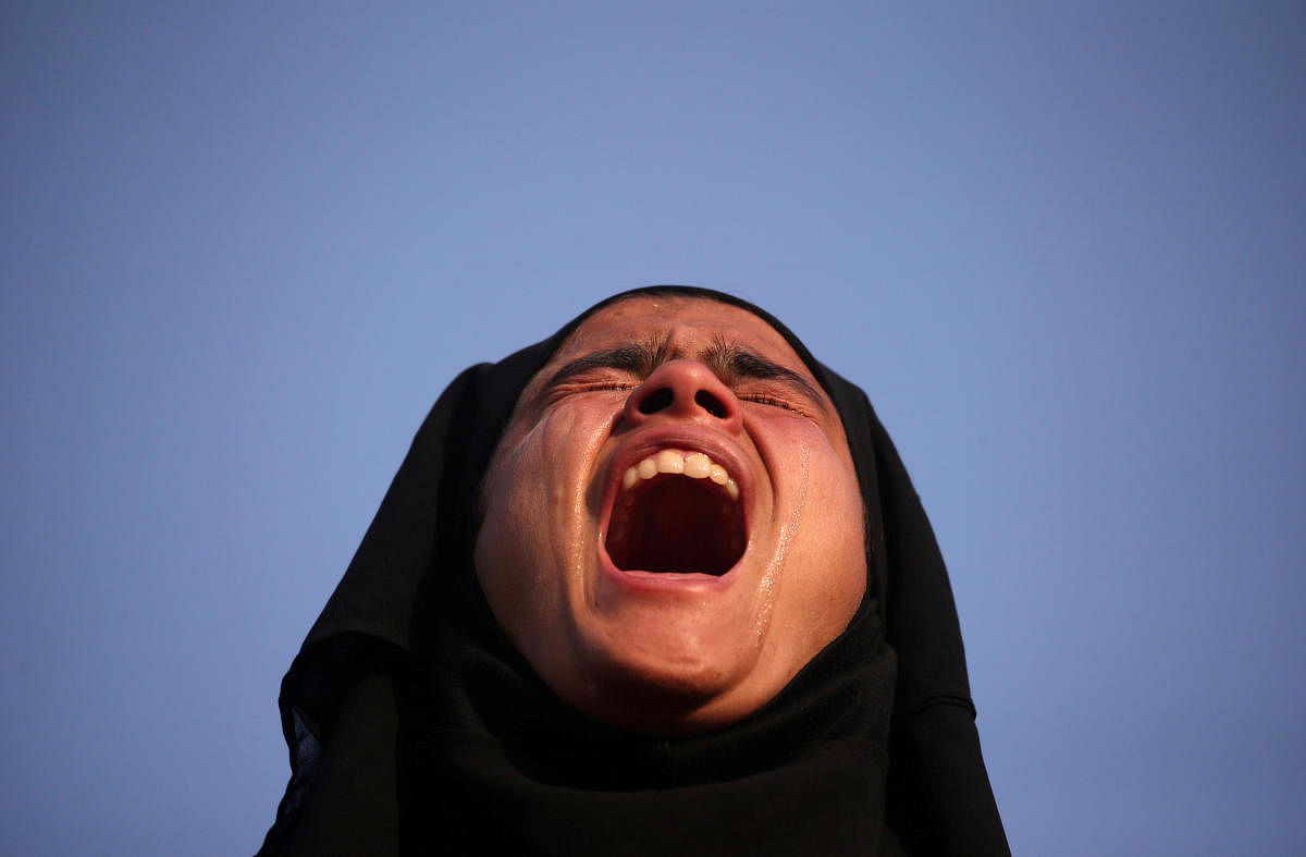 A girl cries as she watches the body of Mehraj-ud-Din Bangroo, a suspected militant, who according to local media was killed in a gunbattle with security forces, during his funeral procession in Srinagar on October 17, 2018. (REUTERS)