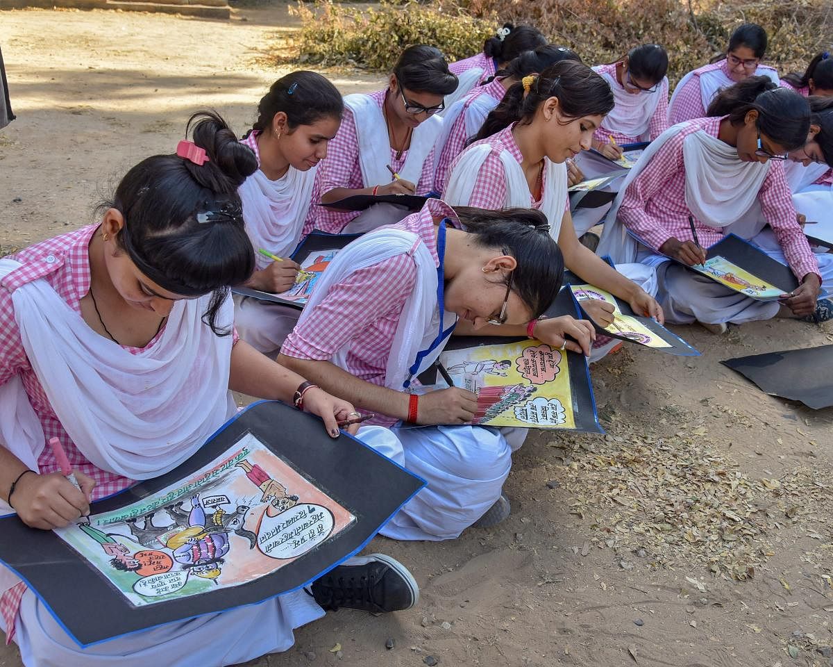Students participate in a competition on making political posters during an election awareness campaign, in Bikaner, on Tuesday. PTI