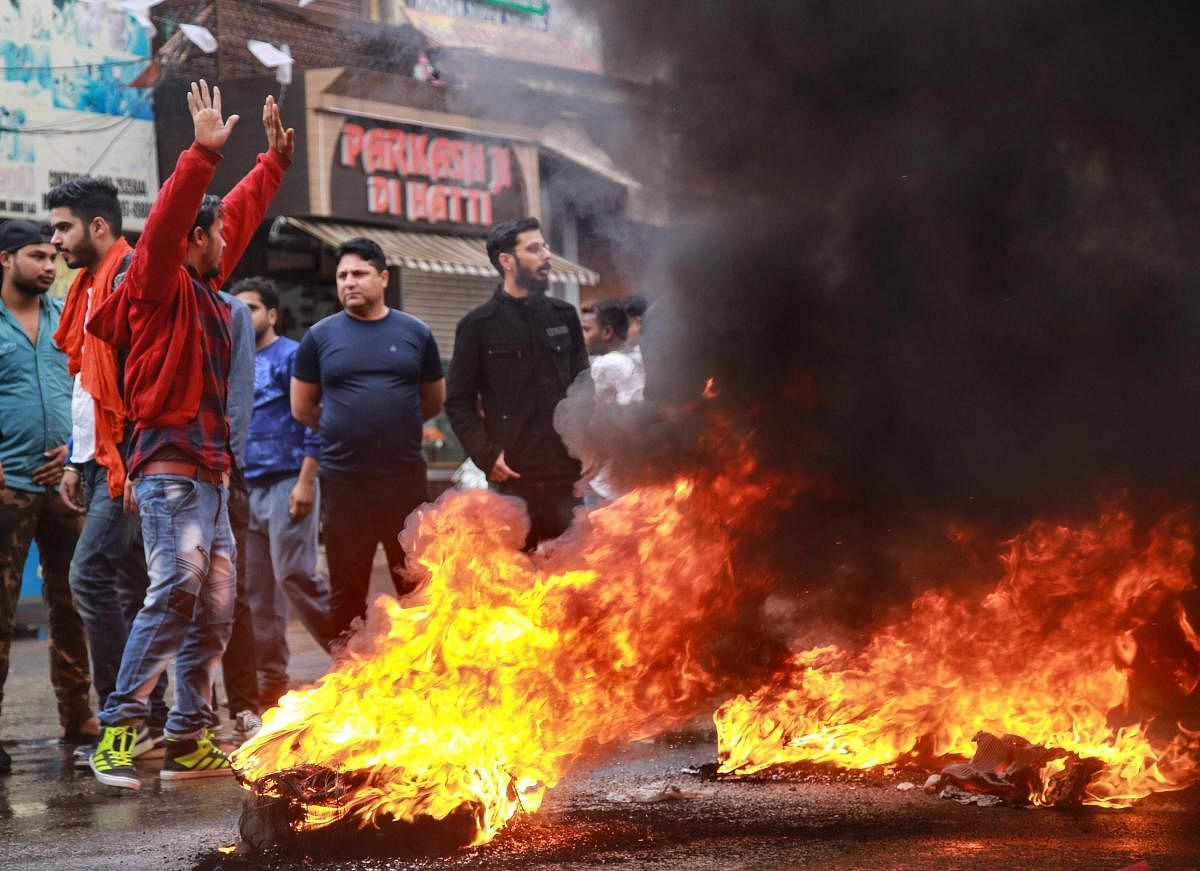 Youth burn tyres during a protest against the killing of BJP state secretary Anil Parihar (52) and his brother Ajeet (55), by militants while they were returning to their Kishtwar home yesterday, in Jammu, Friday, Nov 02, 2018. (PTI Photo)