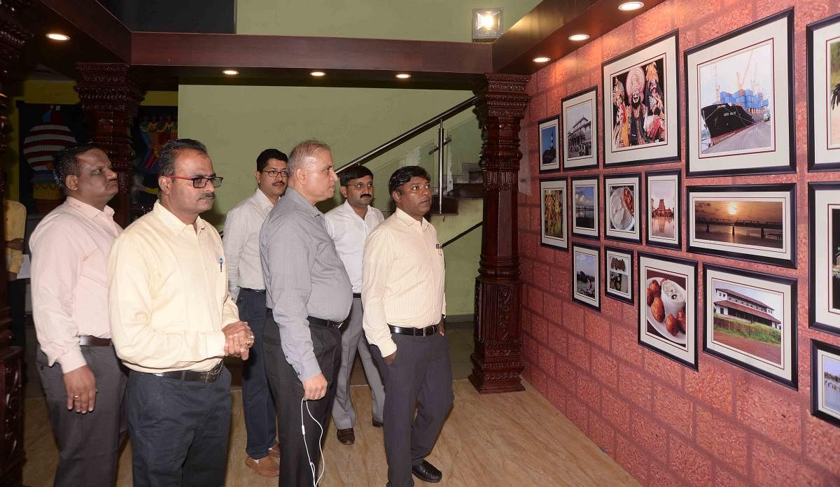 Deputy Commissioner Sasikanth Senthil looks at the photographs displayed at the information kiosk, at New Mangalore Port.