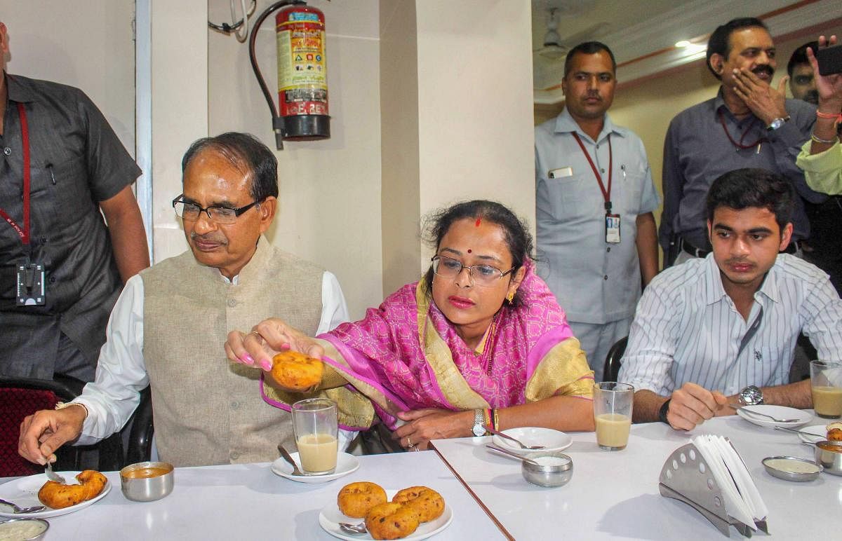 Madhya Pradesh Chief Minister Shivraj Singh Chouhan along with his wife Sadhna Singh and son Kunal Singh Chouhan enjoys snacks during a visit to Indian Coffee House in Bhopal on Tuesday. PTI