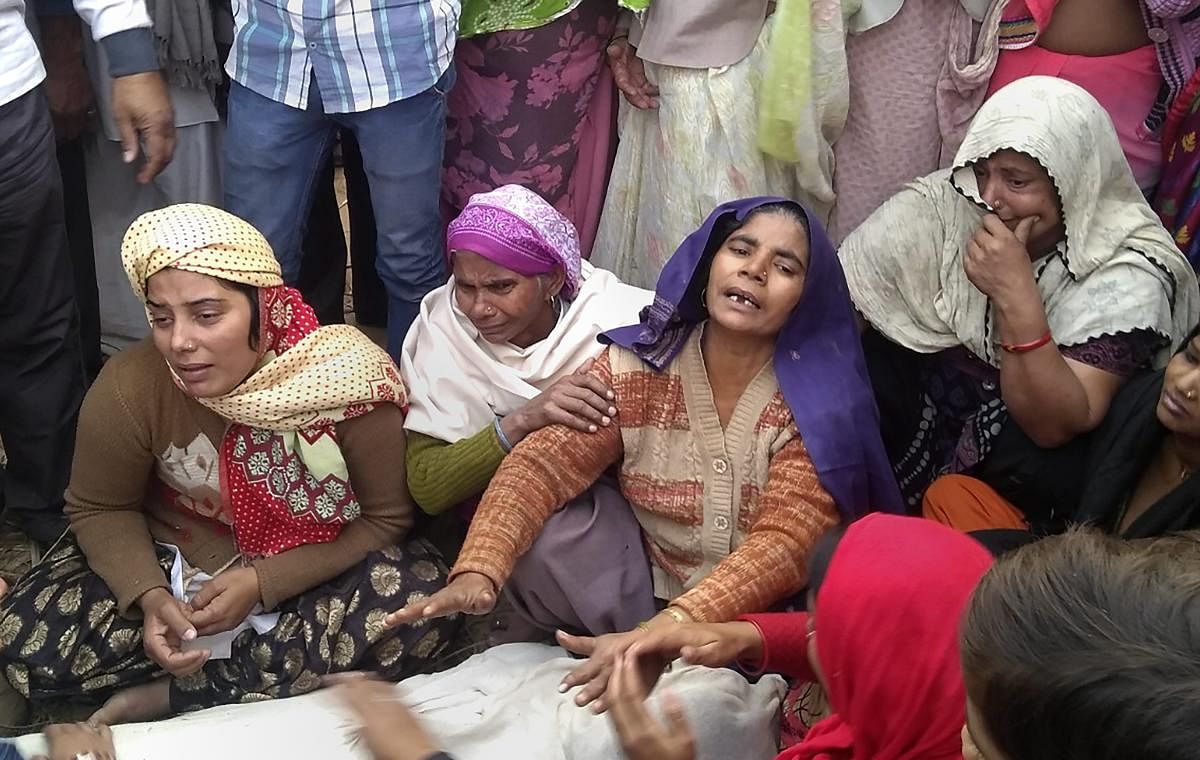 Family members mourn near the body of 20-yr old Sumit Kumar, who was killed in Monday's mob violence, at their village Chingrawati, in Bulandshahr, on Tuesday. PTI