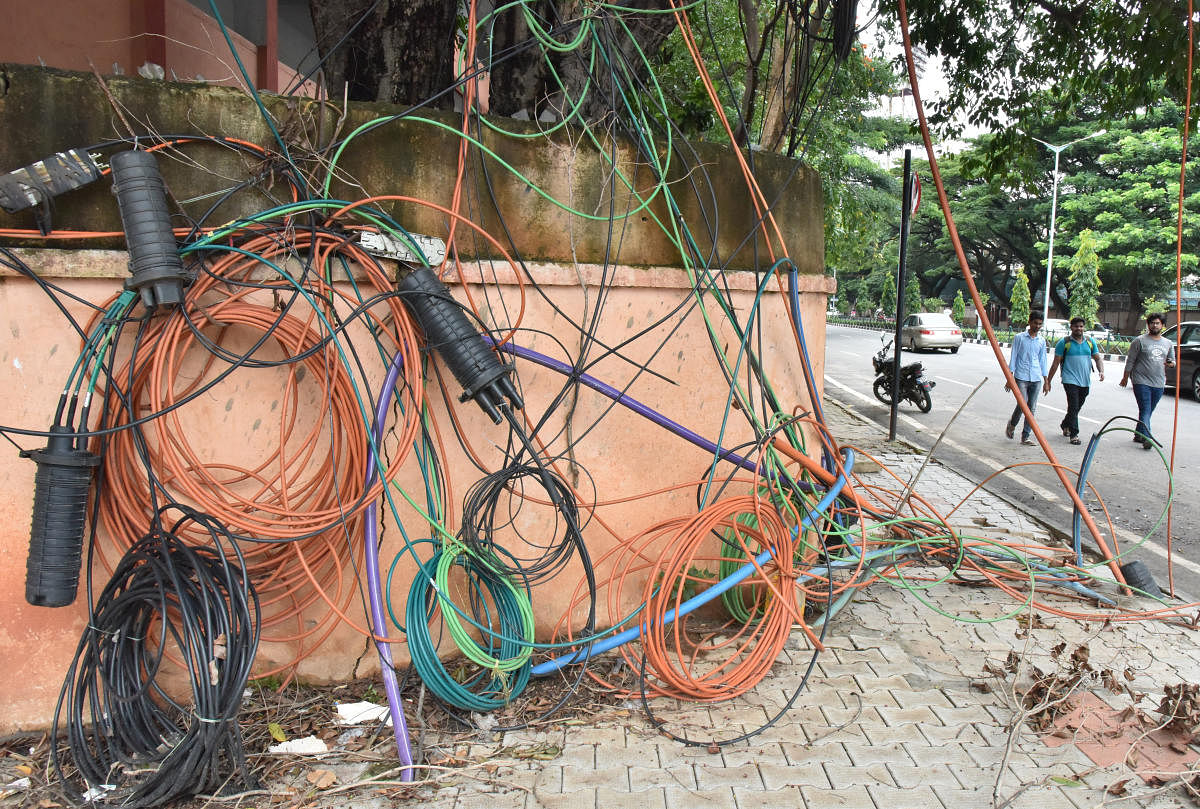Optical fibre cables laid haphazardly on a pavement on Cubbon Road in Bengaluru. DH file Photo