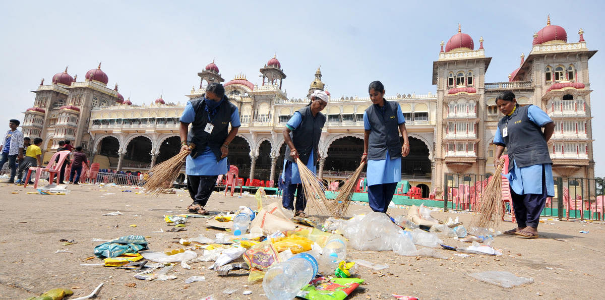 Civic workers clean Mysuru Palace premises, where thousands of people gathered to witness Dasara Jamboo Savari, on Saturday.