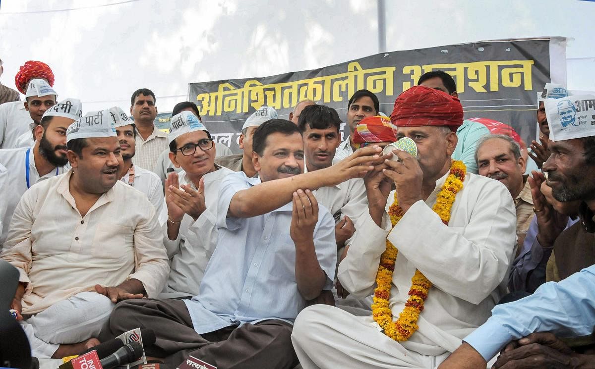 elhi Chief Minister Arvind Kejriwal gives juice to Rajasthan Farmer Leader Rampal Jat to break his hunger strike over farmer's issues, in Jaipur, Sunday, Oct 28, 2018. (PTI Photo)