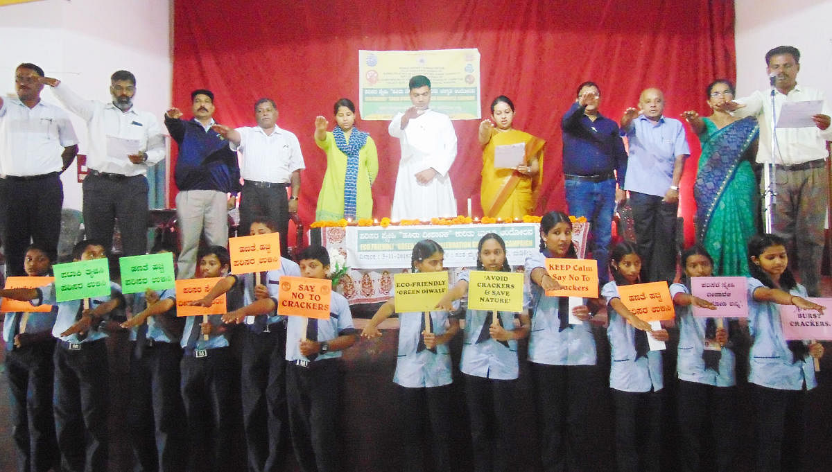District officials, staff and students take a pledge to observe an eco-friendly green Deepavali, at St Michael High School in Madikeri on Saturday.
