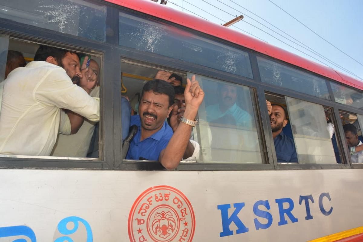 Police bundle BJP protesters into a bus in Chikkamagaluru on Friday.