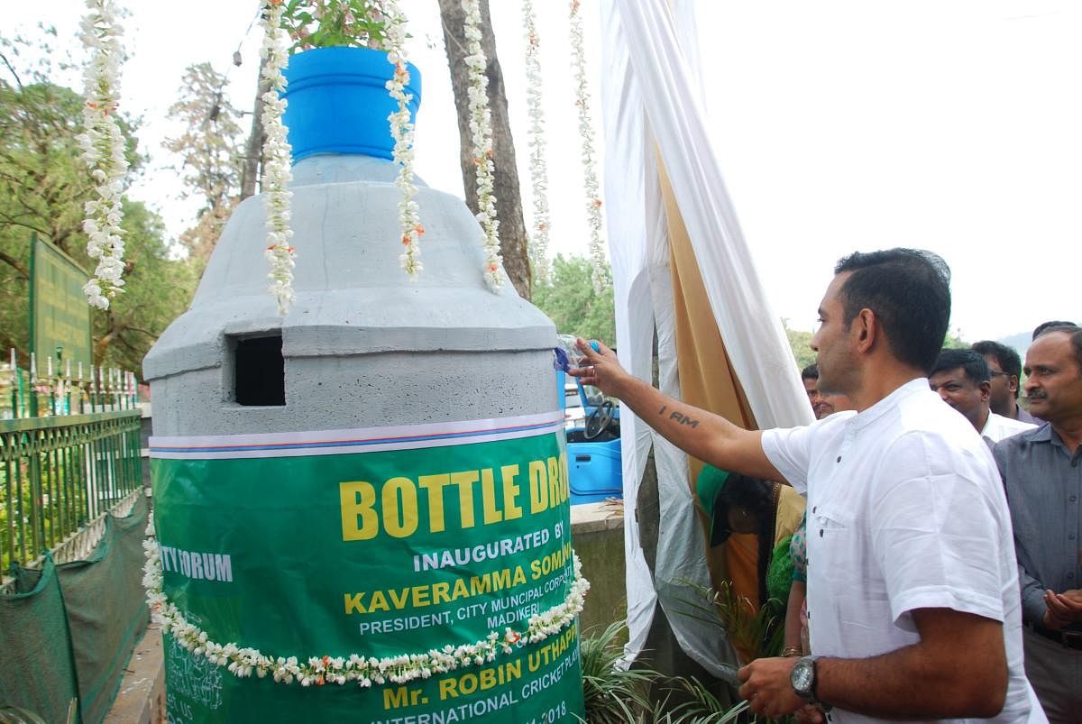 Cricketer Robin Uthappa inaugurates the bottle dropper as part of the World Heritage Day and World Toilet Day programme at Raja Seat in Madikeri on Monday.