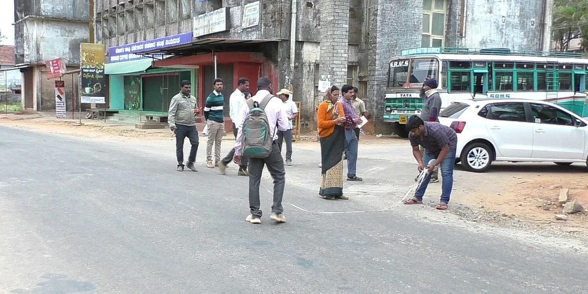 Marking work being carried out for the widening of Raja Seat Road, in Madikeri, on Friday.