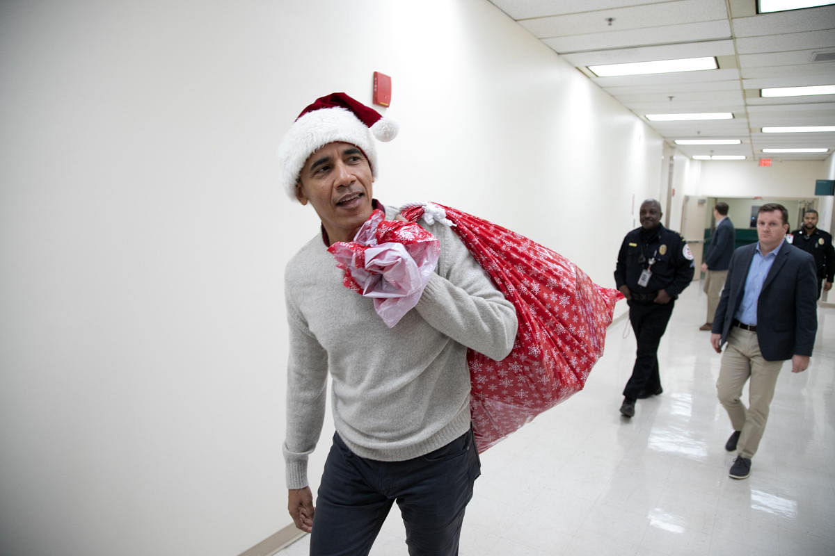 This photograph, obtained courtesy of the Obama Foundation, shows former US President Barack Obama delivering gifts, greeting patients and their parents at Children’s National Medical Center in Washington, DC, December 19, 2018. (Photo by Chuck Kennedy)