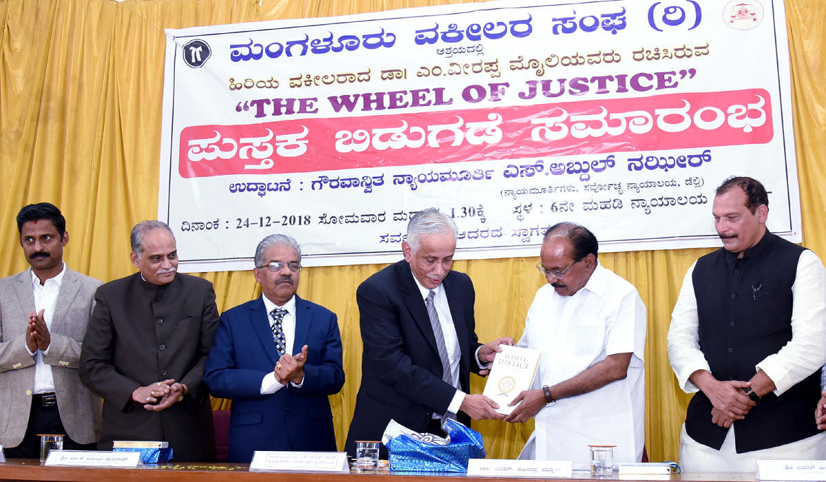 Supreme Court judge Justice S Abdul Nazeer releases former Union minister Veerappa Moily’s book ‘The Wheel of Justice’ at the district court complex in Mangaluru on Monday.