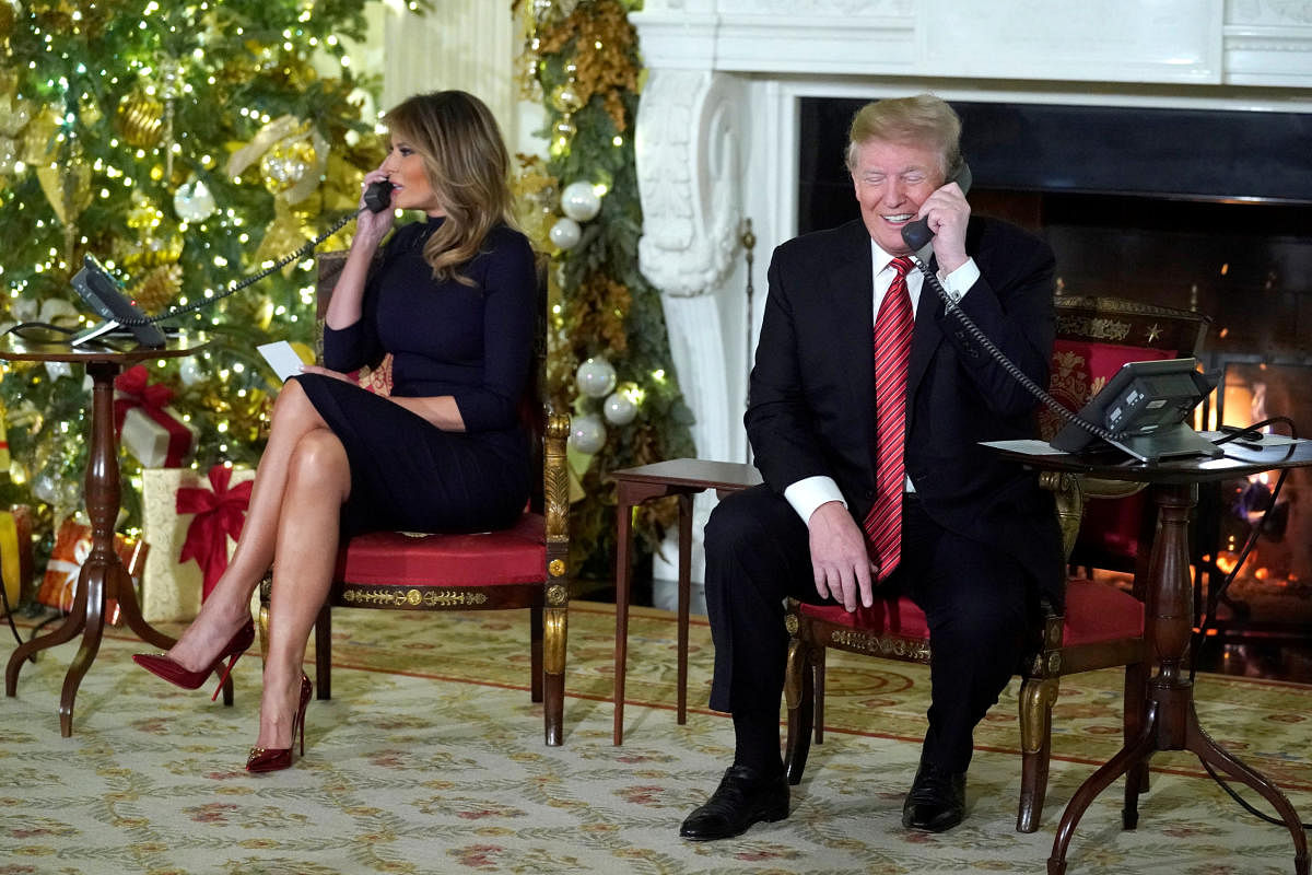 US President Donald Trump and first lady Melania Trump participate in NORAD Santa tracker phone calls from the White House in Washington on Monday. (REUTERS)