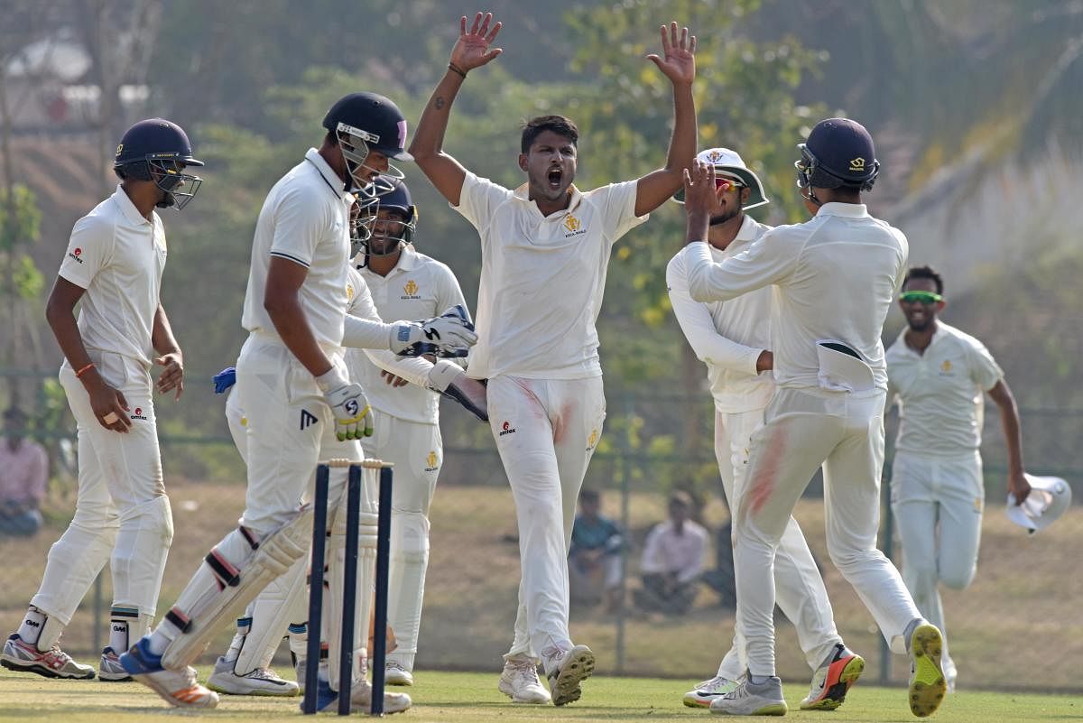 TIMELY: K Gowtham (centre) of Karnataka celebrates after claiming another Railways' wicket in the Ranji Trophy match in Shivamogga on Tuesday. DH Photo/ S K Dinesh