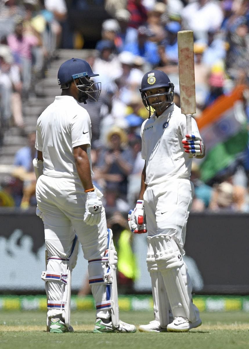 COMPOSED KNOCK: India's Mayank Agarwal (right) celebrates his half-century with team-mate Cheteshwar Pujara on the first day of the third Test at the Melbourne Cricket Ground in Melbourne on Wednesday. AP/PTI