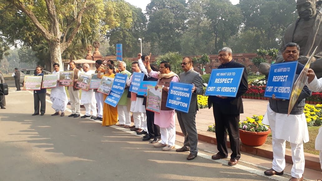 MPs from Karnataka stage protest in front of Mahatma Gandhi statue in the Parliament complex demanding early implementation of Mekedatu project on Thursday. (DH Photo)