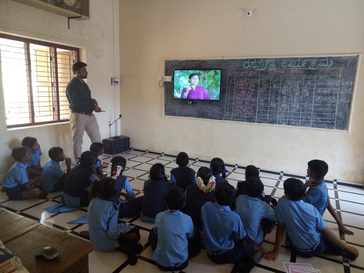 A teacher teaches at a smart classroom in Dakshina Kannada Zilla Panchayat Higher Primary School in Perabe, Puttur taluk.