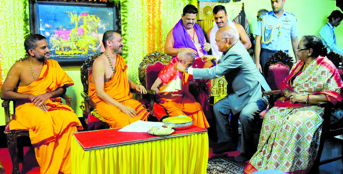 The President Ram Nath Kovind felicitates Pejawar Mutt Pontiff Vishwesha Teertha Swami, who completed 80 years of asceticism, in Udupi on Thursday.