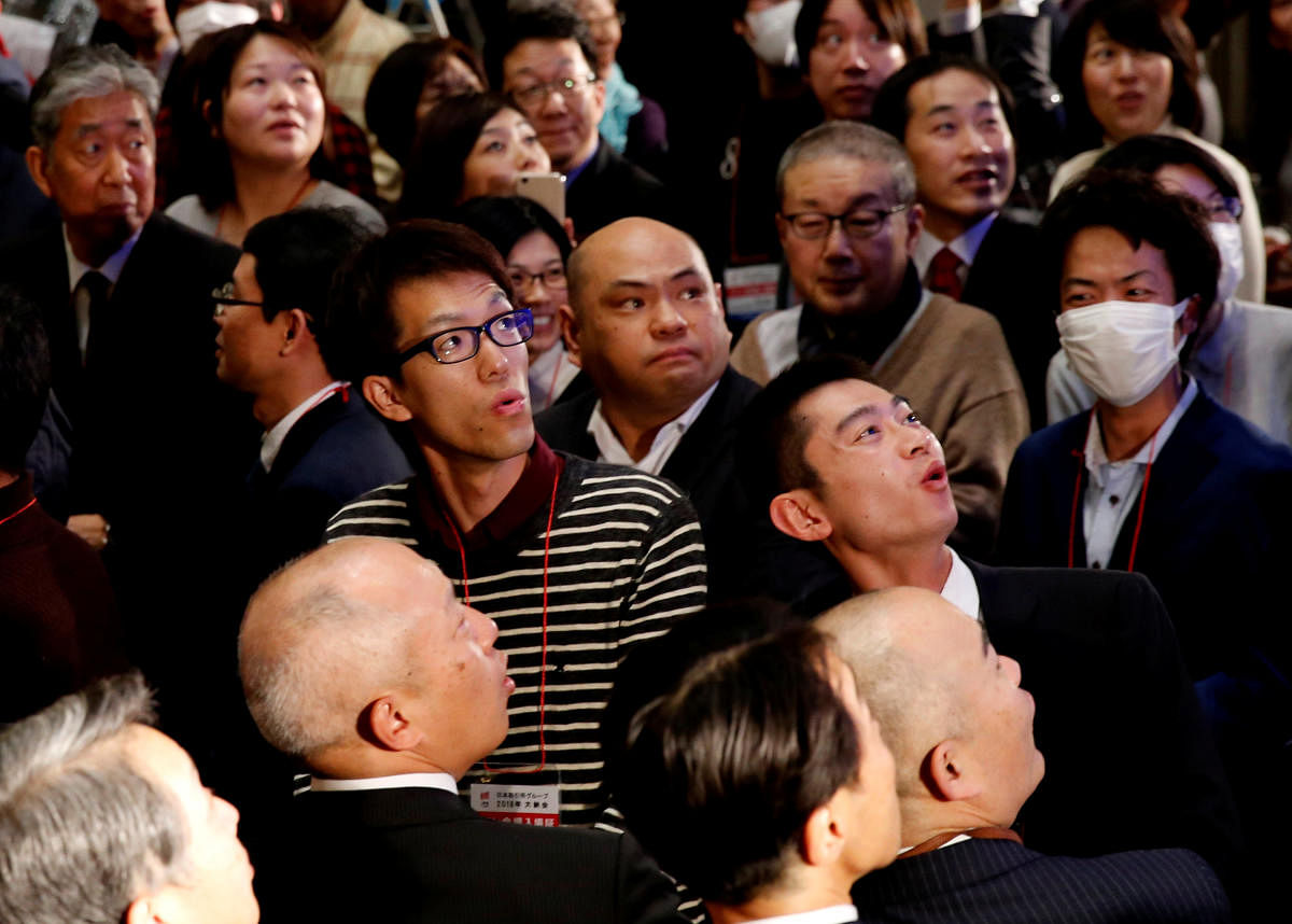 Attendees react as they look at the closing price of Nikkei index on a stock quotation board during a ceremony marking the end of trading in 2018 at the Tokyo Stock Exchange (TSE) in Tokyo, Japan December 28, 2018. (REUTERS)