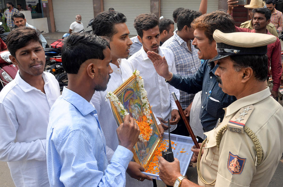 Police prevent BJP Yuva Morcha members, led by Nishanth, from staging a protest with a photograph of Lord Rama in front of rationalist-writer K S Bhagawan's residence in Mysuru on Friday. DH photo