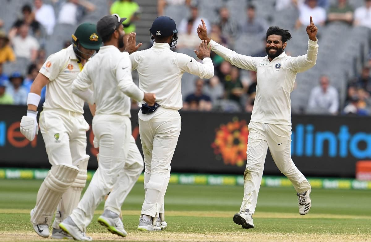 India's Ravindra Jadeja (R) celebrates taking a wicket of Australia's batsman Marcus Harris (L) with teammates during day four of the third cricket Test match between Australia and India in Melbourne on December 29, 2018. (AFP Photo)