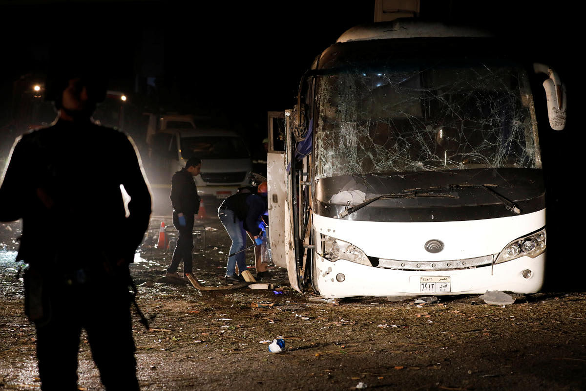 Police officers inspect a scene of a bus blast in Giza, Egypt, on Friday. (REUTERS)
