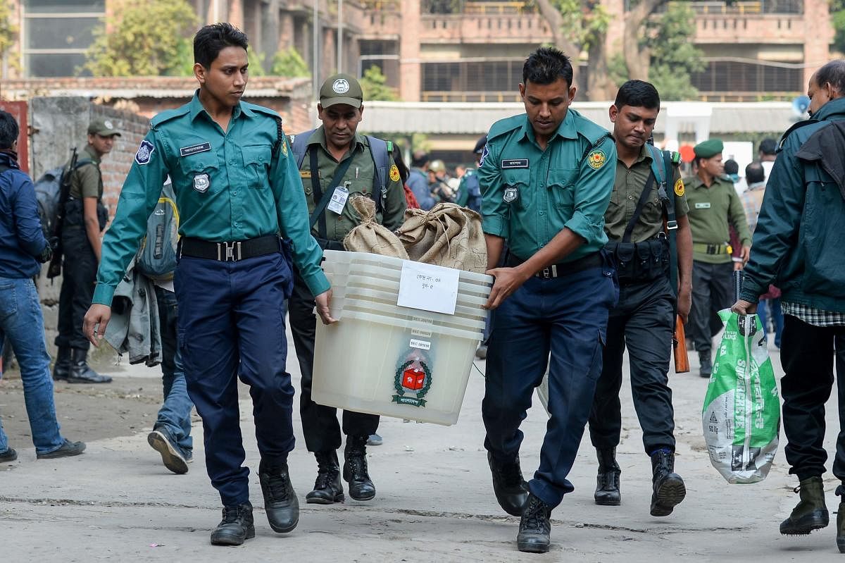 Bangladeshi security personnel carry polling materials at distributing center in Dhaka on December 29, 2018. - Bangladesh stepped up security on December 29 in a bid to contain violence during a general election expected to see Prime Minister Sheikh Hasin