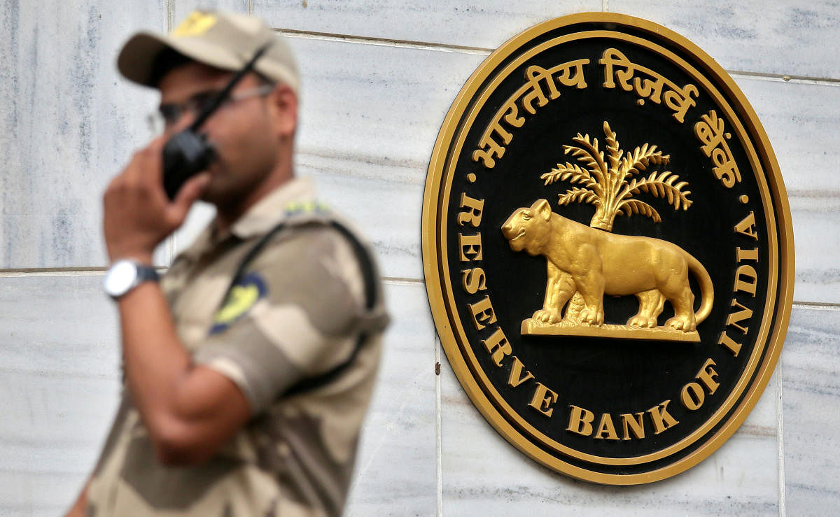 FILE PHOTO: A guard stands next to the Reserve Bank of India (RBI) logo outside its headquarters in Mumbai, India, October 5, 2018. REUTERS/Francis Mascarenhas/File Photo