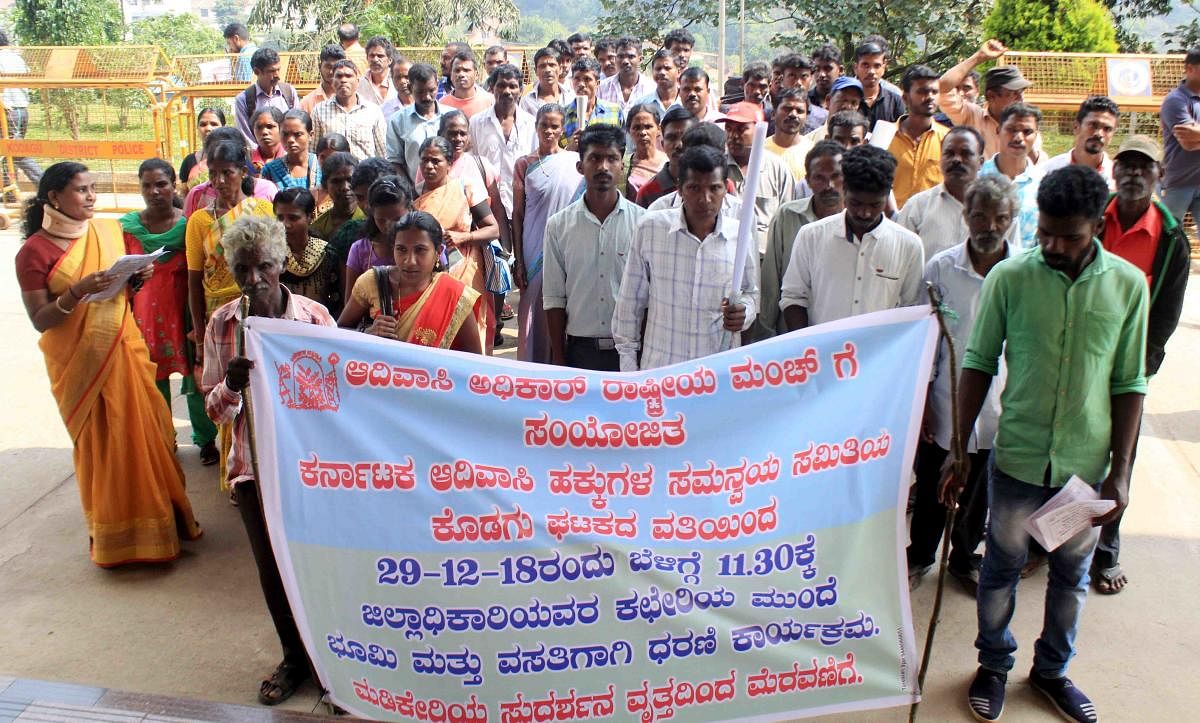 Members of Karnataka Adivasi Hakkugala Samanvaya Samithi stage a protest in Madikeri on Saturday.