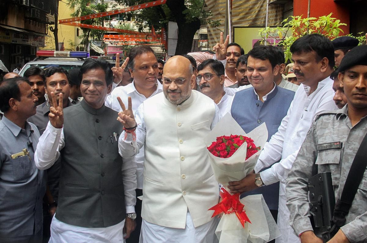 BJP President Amit Shah with Maharashtra Chief Minister Devendra Fadnavis and BJP state unit president Raosaheb Danve arrives for a party meeting at Dadar, in Mumbai on Sunday, July 22, 2018. (PTI Photo)