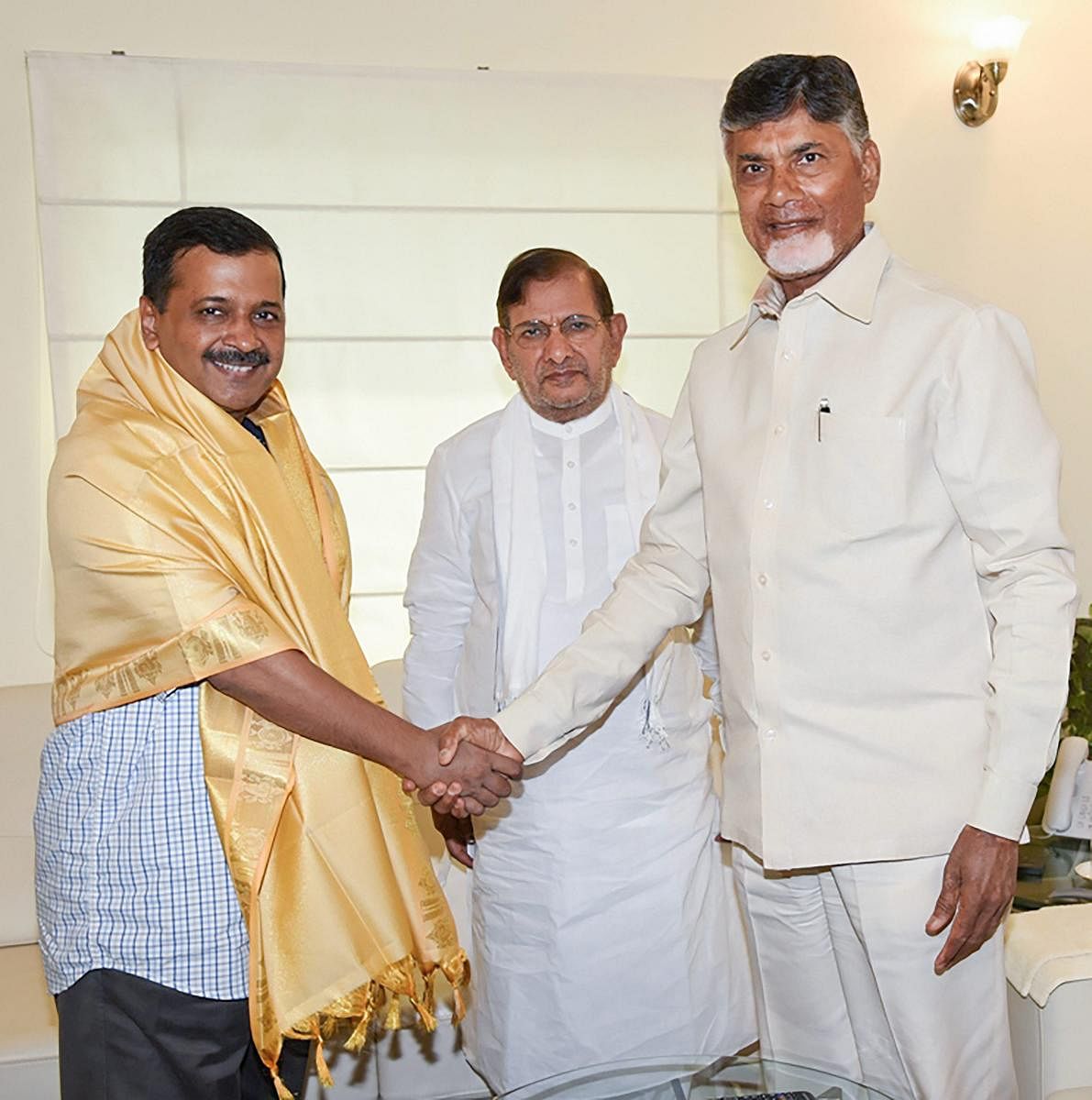 Chief Minister of Andhra Pradesh Nara Chandrababu Naidu greets his Delhi counterpart Arvind Kejriwal as Sharad Yadav looks on, in New Delhi, on Saturday. PTI