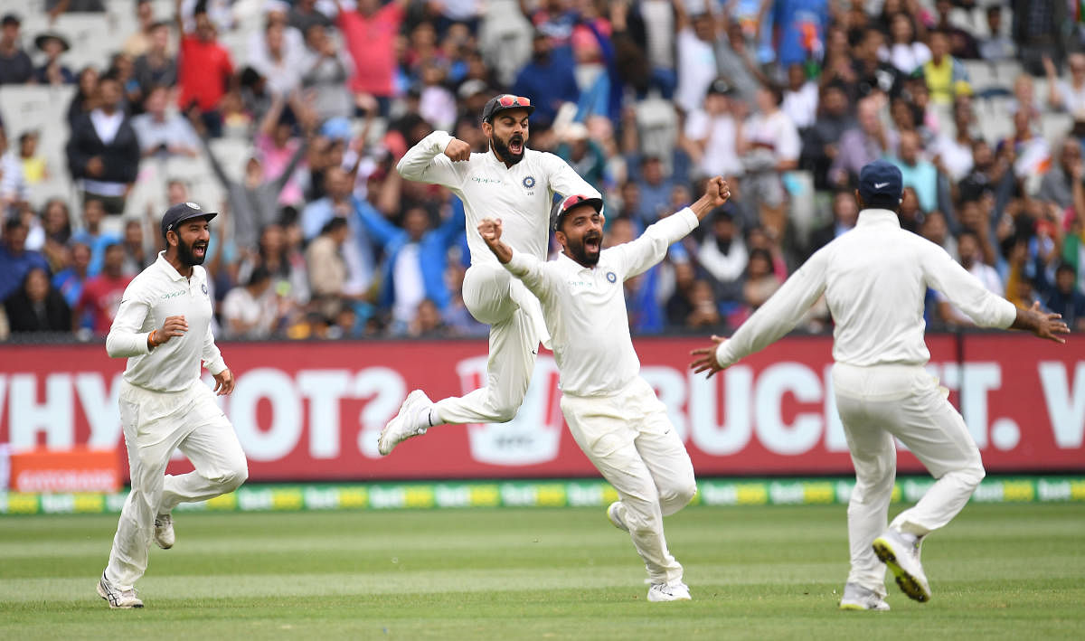 Thunder down under: Virat Kohli (2nd L) celebrates with Cheteshwar Pujara and Ajinkya Rahane after winning the third test match against Australia at the MCG in Melbourne. Reuters