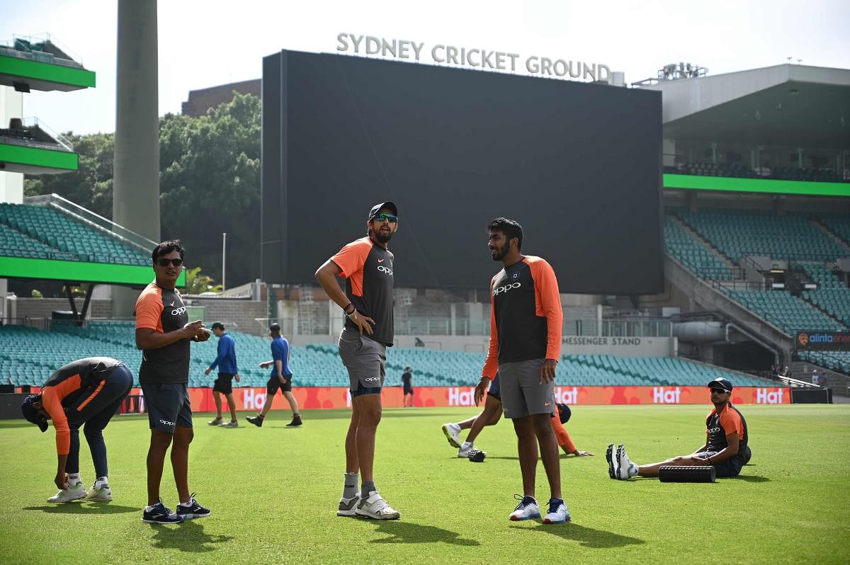India's fast bowlers Ishant Sharma (centre L) and Jasprit Bumrah (centre R) warm up with their teammates before training ahead of the fourth and final Test against Australia at the Sydney Cricket Ground in Sydney on January 2, 2019. (Photo by Peter PARKS
