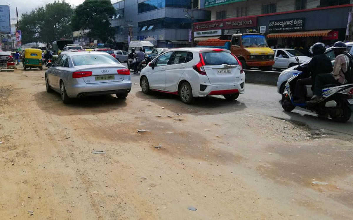 The Hennur-Bagaluru Road at Hennur Cross. The digging has shrunk the tarred road resulting in traffic pile-up. (DH Photo)
