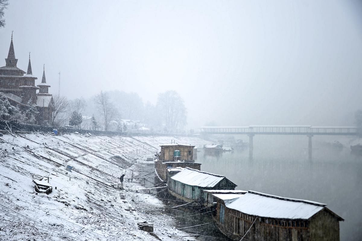 Houseboats covered by snow are seen along the banks of Jehlum river during a snowfall in Srinagar on January 4, 2019. (AFP Photo)