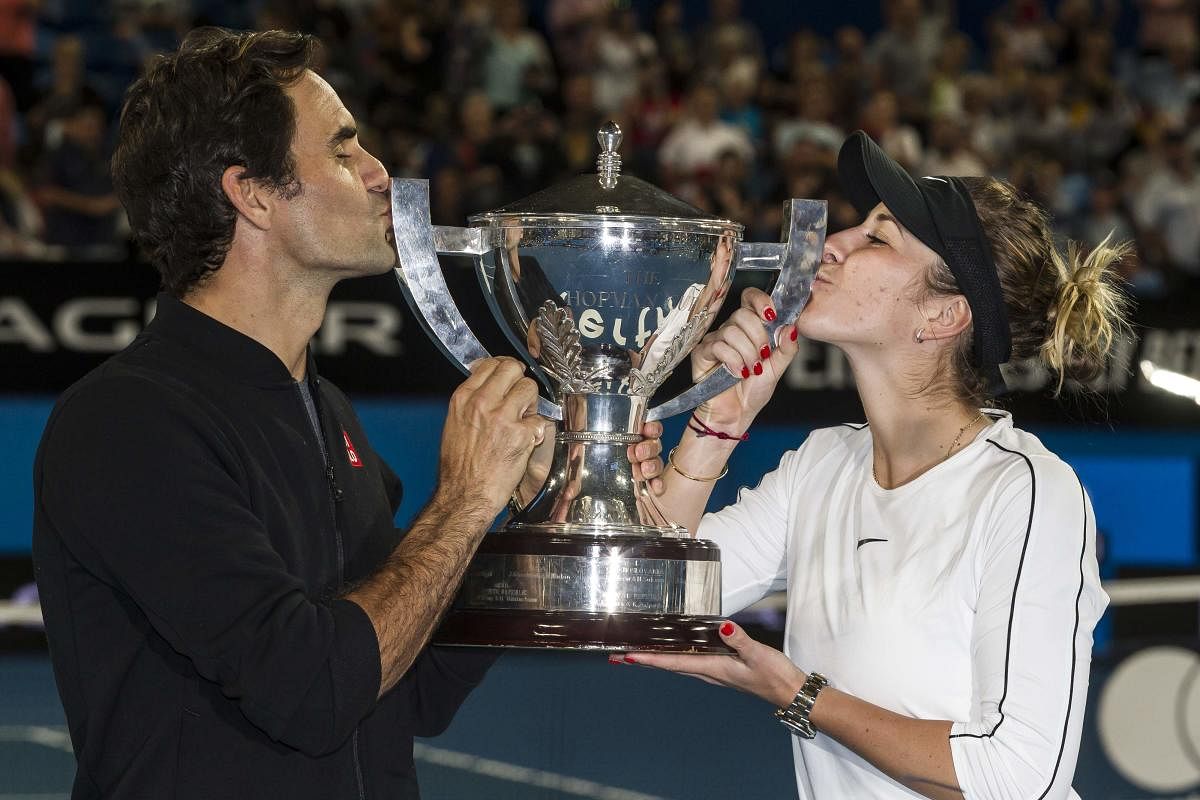 Switzerland's Roger Federer (left) and Belinda Bencic kiss the Hopman Cup after beating Germany in the final on Saturday. AFP