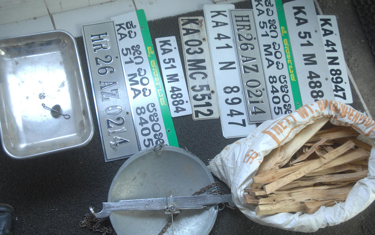 Seized weighing scale, number plates and nine kilogram of sandalwood in police custody.