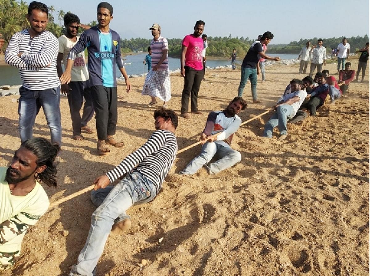 Men take part in tug of war held as a part of the Beach Utsav at Kalihithlu in Shiroor.
