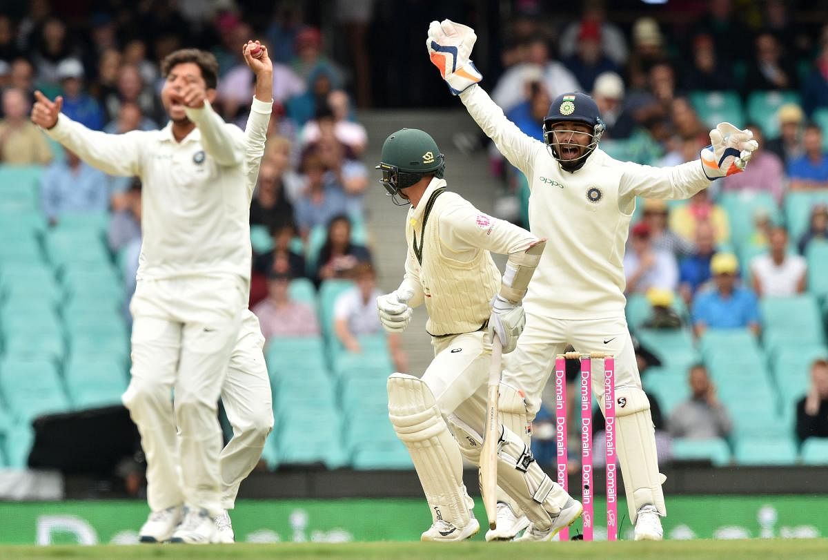 Australia's batsman Nathan Lyon is bowled LBW by India's Kuldeep Yadav (L), as India's wicketkeeper Rishabh Pant (R) shouts, on the fourth day of the fourth and final cricket Test at the Sydney Cricket Ground in Sydney on January 6, 2019. (AFP Photo) 