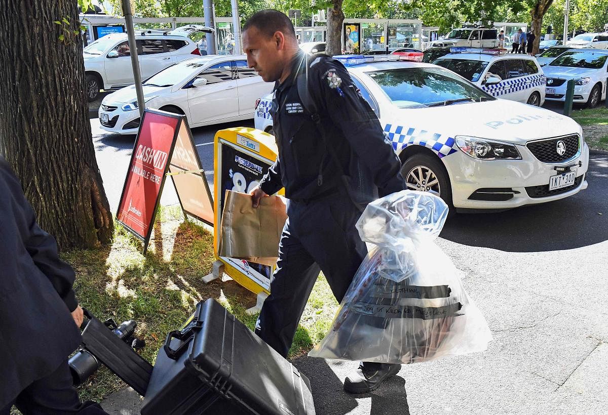 A Victoria Police forensic officer carries items to be loaded into a trailer outside the Italian consulate in Melbourne on January 9, 2019. - Australian police are investigating the delivery of suspicious packages sent to foreign embassies and consulates