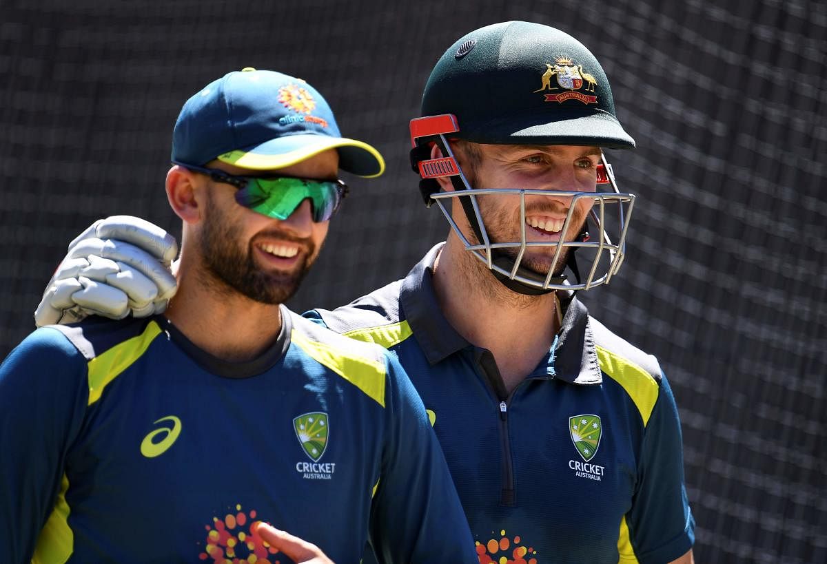 Australia's all-rounder Mitch Marsh (R) shares a lighter moment with teammate Nathan Lyon (L) during training in Melbourne. AFP file photo.