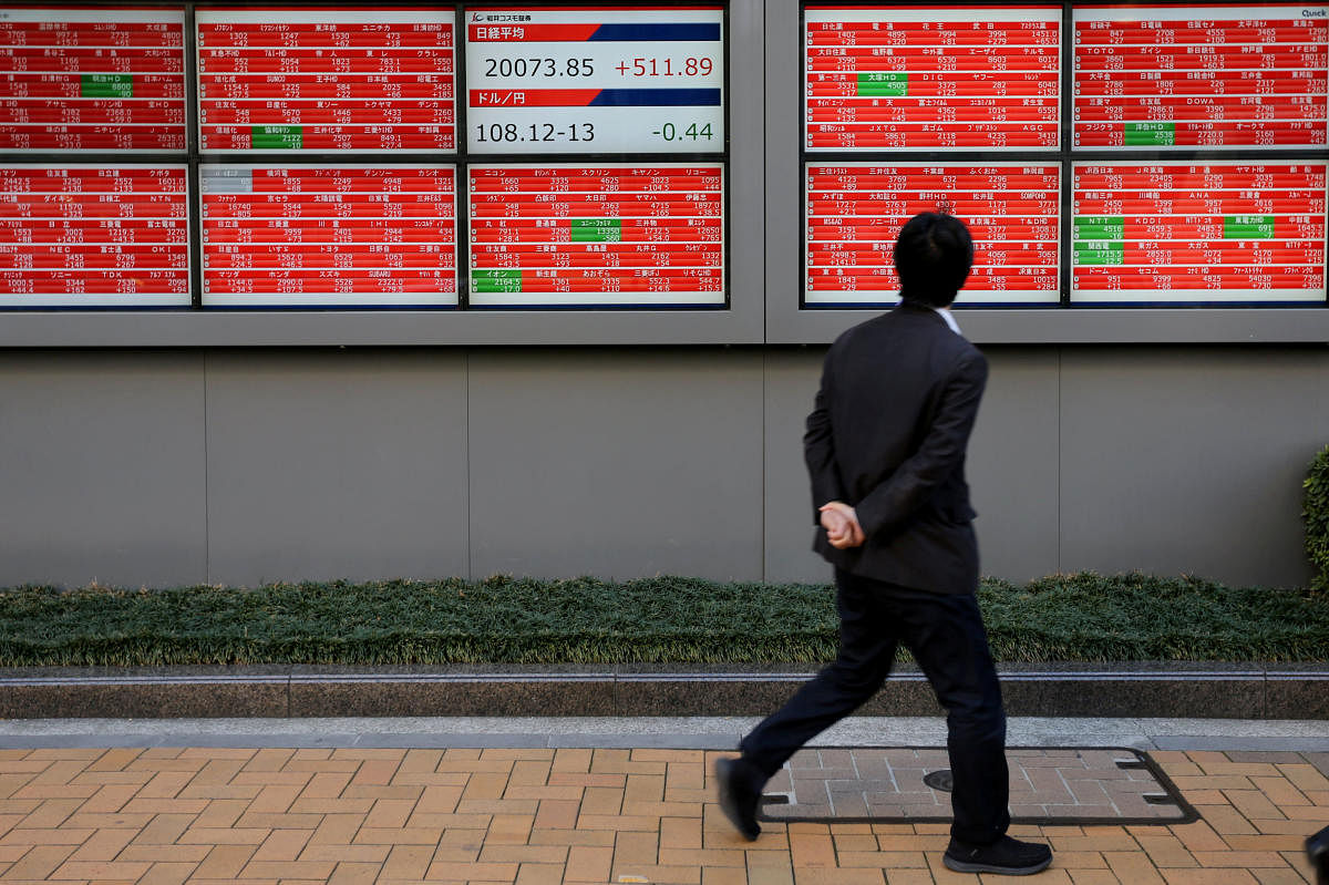 A man looks at an electronic board showing the Nikkei stock index outside a brokerage in Tokyo, Japan. Reuters file photo.