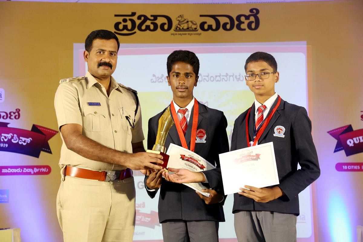 Proud Winners: Superintendent of Police A N Prakash Gowda presents prizes to winners of Prajavani zonal quiz championship, to Stevan and Jobin of Christ School, in Hassan on Wednesday. dh photo