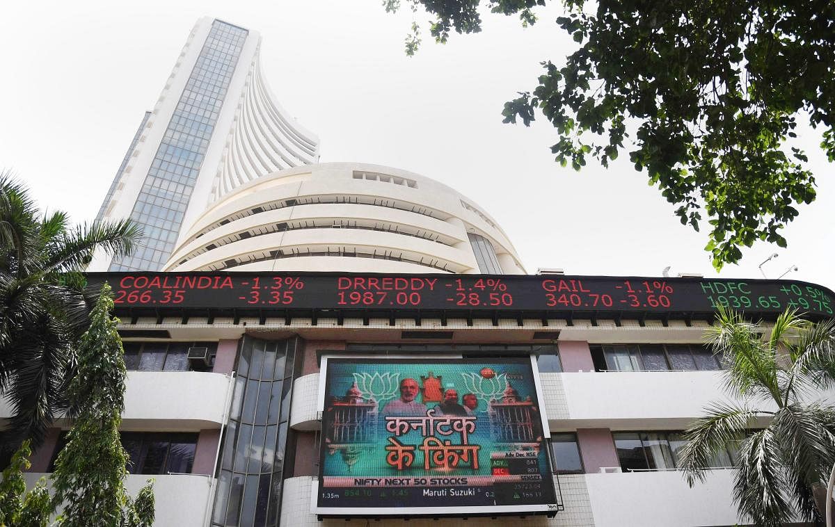 A display board on the facade of Bombay Stock Exchange building shows news on the Karnataka polls, in Mumbai on Tuesday. After surging over 436 points in the day the Sensex slipped into the negative territory at the end as trends indicated BJP falling sho